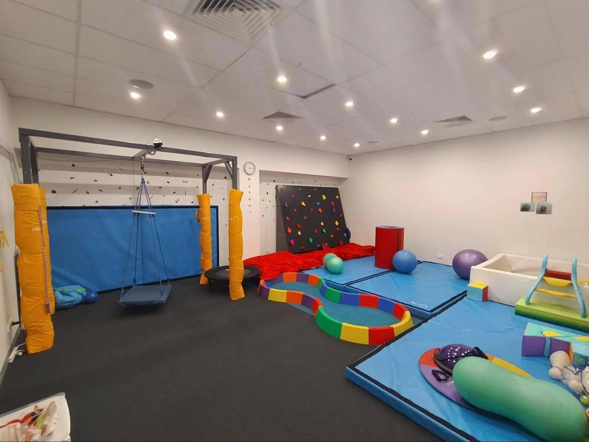 Large therapy room with movement and sensory equipment at Marsden Therapy