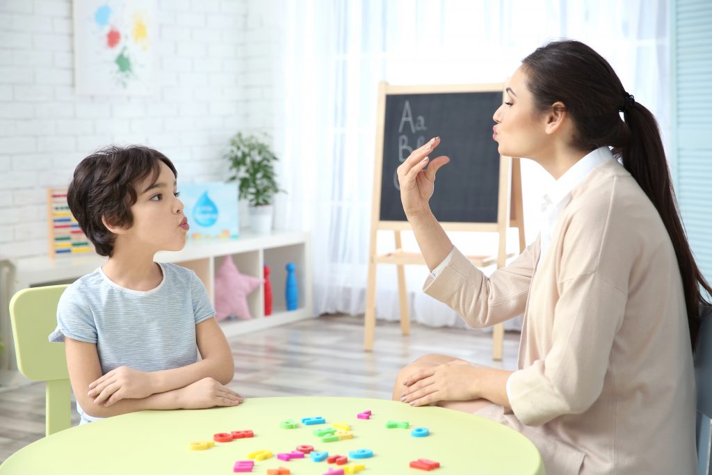 Speech therapy to a child by a teacher